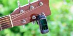 A guitar tuner placed on the headstock