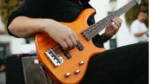 A person playing a bass guitar